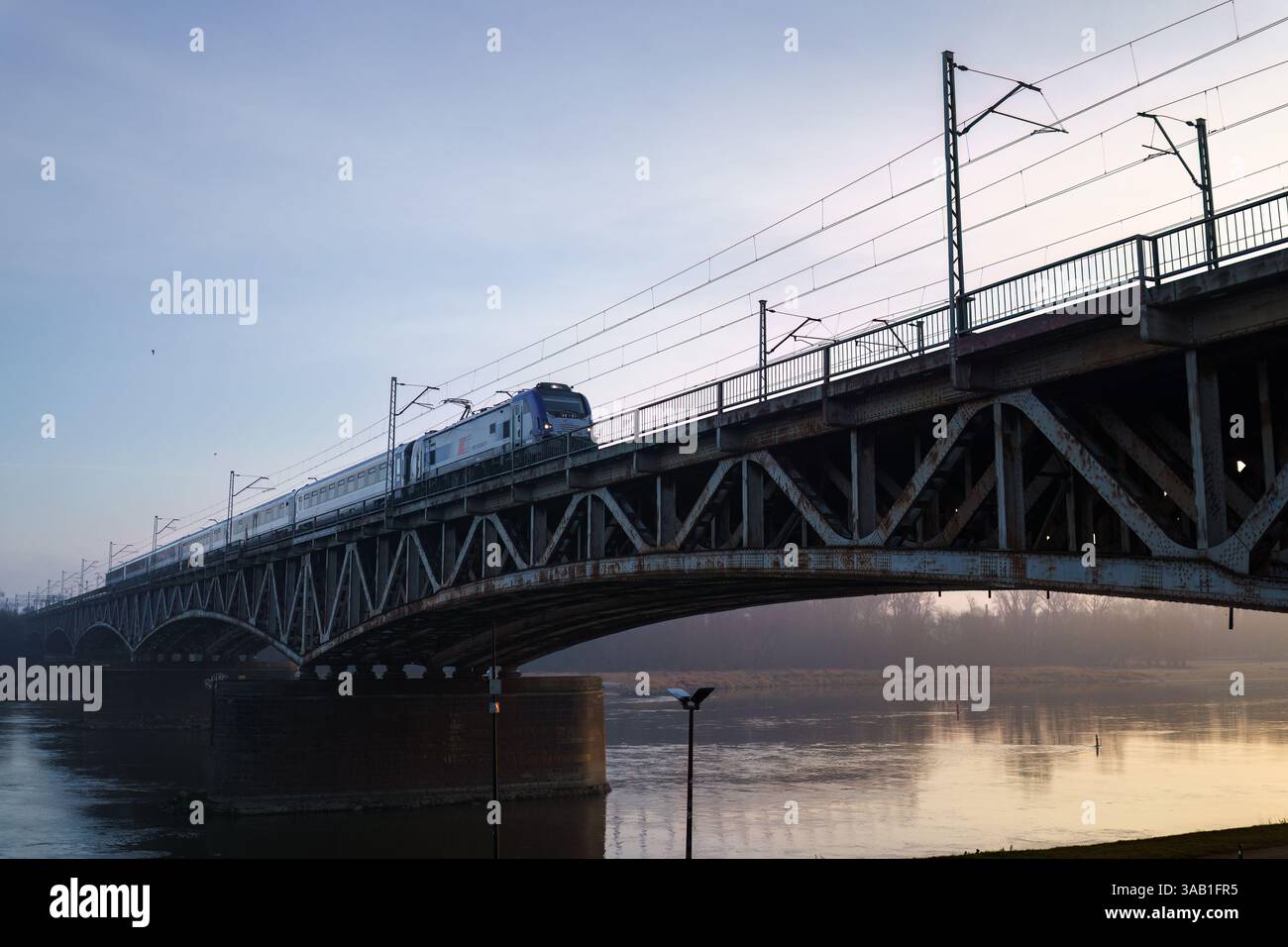 Warschau, Polen. 27. Januar 2025: Zugüberquerung der Srednicowy Railway Bridge am frühen Morgen Stockfoto