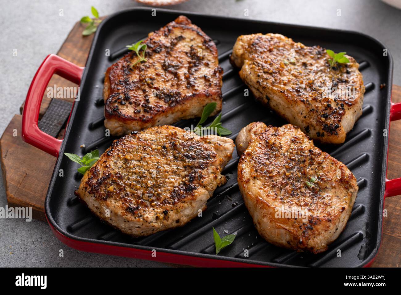 Schweinekoteletts mit Kräutern und Knoblauch, gegrillt oder in einer Pfanne anbraten, einfache Idee für das Hauptgericht Stockfoto