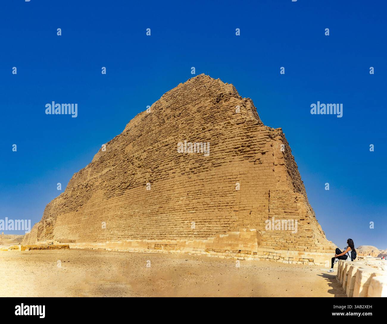 Kairo, Ägypten; 20. Januar 2024: Beobachten Sie einen Touristen, der die große Stufenpyramide von Zoser in Sakkara, Ägypten, der Nekropole der Antike, betrachtet Stockfoto