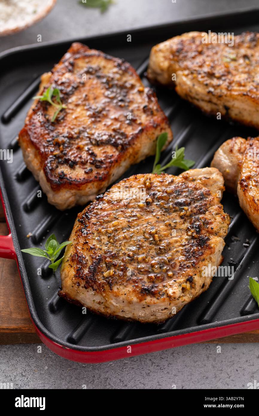 Schweinekoteletts mit Kräutern und Knoblauch, gegrillt oder in einer Pfanne anbraten, einfache Idee für das Hauptgericht Stockfoto