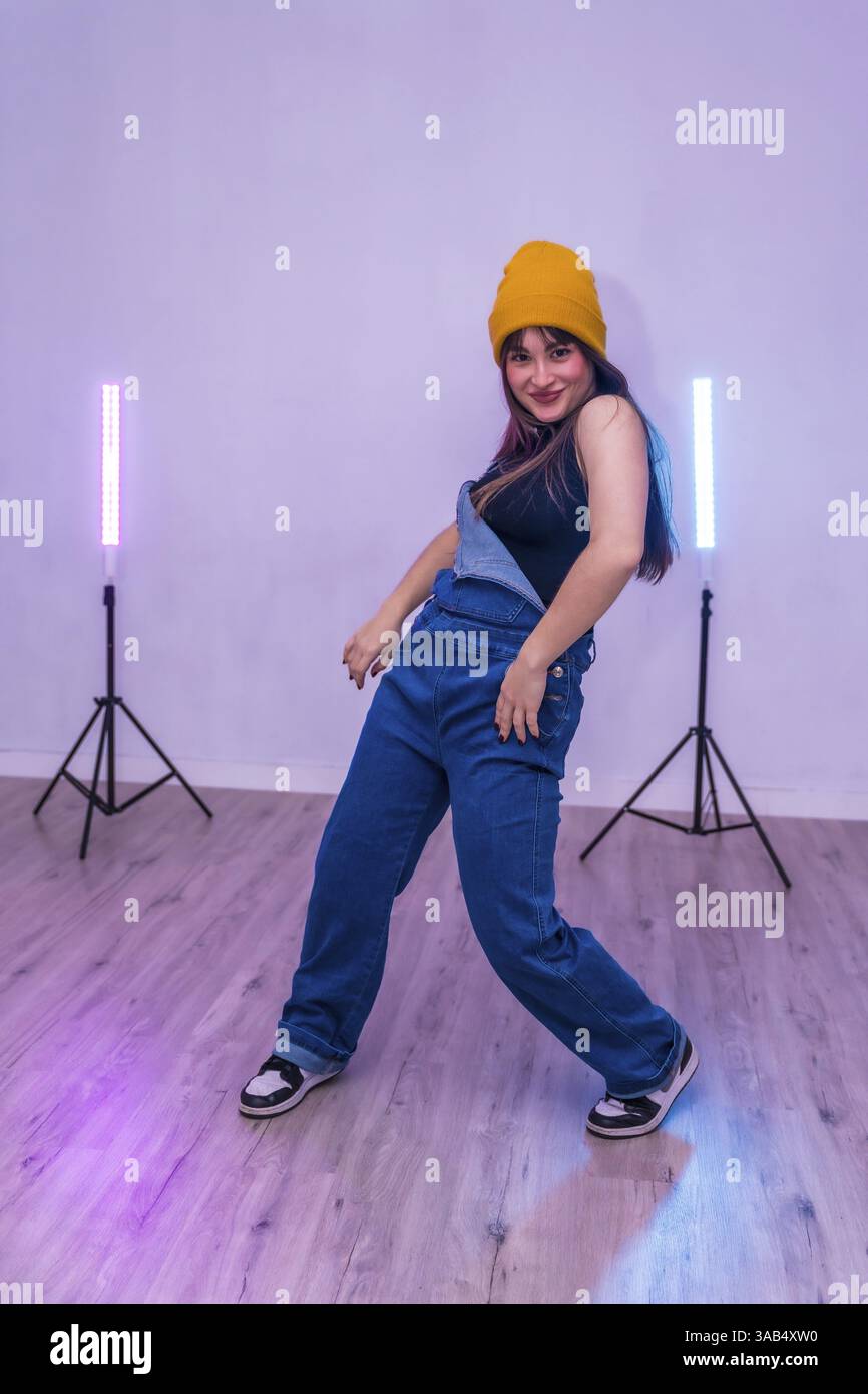 Talentierte junge Tänzerin, die eine moderne Choreographie in einer Tanzakademie mit LED-Lichtern praktiziert Stockfoto