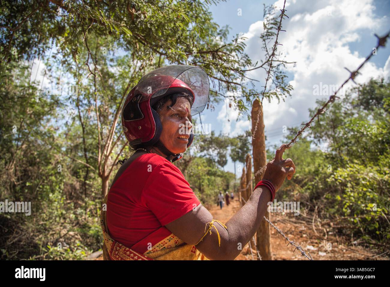 10. April 2015 - Halbinsel Jaffna, Sri Lanka - Rajeswari blickt zum ersten Mal seit 26 Jahren auf die Lage ihres Hauses im Bezirk Valikammam und ist nicht in der Lage, ihr Haus zu erreichen, da es derzeit vom srilankischen Militär besetzt ist. Nur Teile des Landes wurden freigelassen. Der Sri-lankische Bürgerkrieg begann am 23. Juli 1983 und war ein Aufstand gegen die Regierung der Liberation Tigers of Tamil Eelam (LTTE oder Tamil Tigers), die für einen unabhängigen tamilischen Staat Tamil Eelam kämpften. Nach einem 26-jährigen Krieg und schätzungsweise 40.000 zivilen Toten besiegte die srilankische Armee die Tami Stockfoto