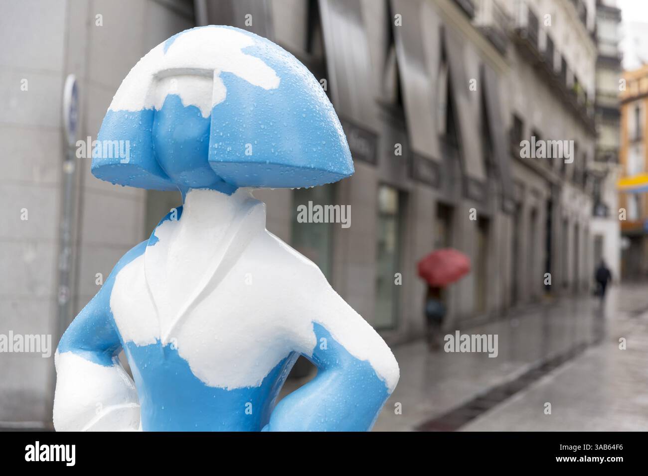 7. Juni 2018 - Madrid, Gemeinschaft Madrid, Spanien - Madrid, Spanien: Eine Frau mit einem Regenschirm passiert eine Skulptur „Menina“ entlang der Calle de TetuÃ¡n. Die Skulptur ist Teil der „Meninas Madrid Gallery“ zu Ehren der berühmten Meninas von VelÃ¡zquez. Das Projekt wird vom Madrider Stadtrat organisiert und vom Künstler Antonio Azzato geleitet. Die Skulptur „Cielo de DÃ­a“ wurde von der Künstlerin Agatha Ruiz de la Prada geschaffen. (Bild: © Paul Gordon via ZUMA Wire) Stockfoto