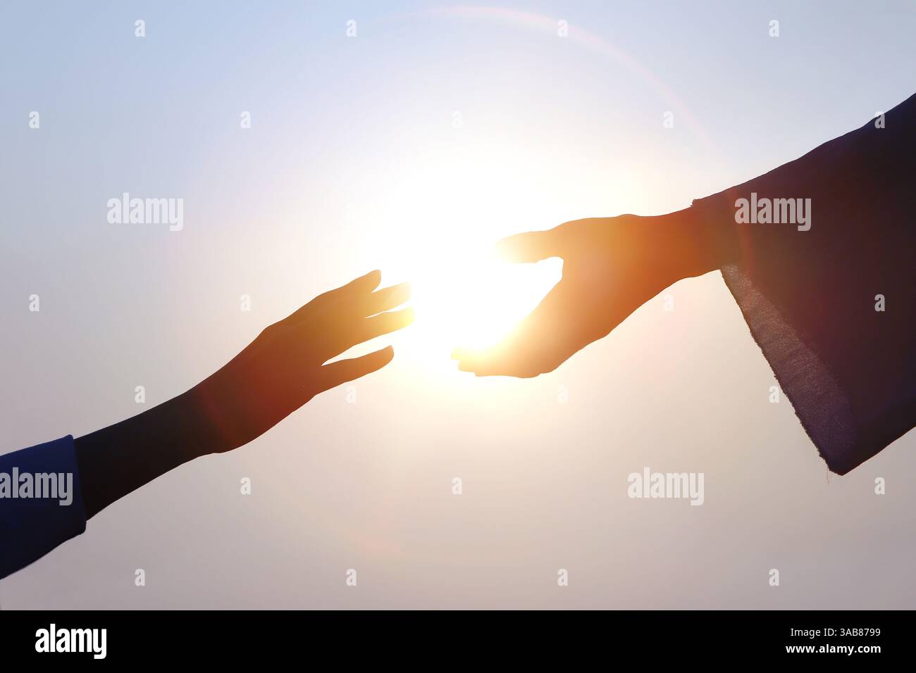 Hand der Erlösung, christliche Hand streckt zur Hand Jesu Christi, helle Sonnensilhouette Stockfoto