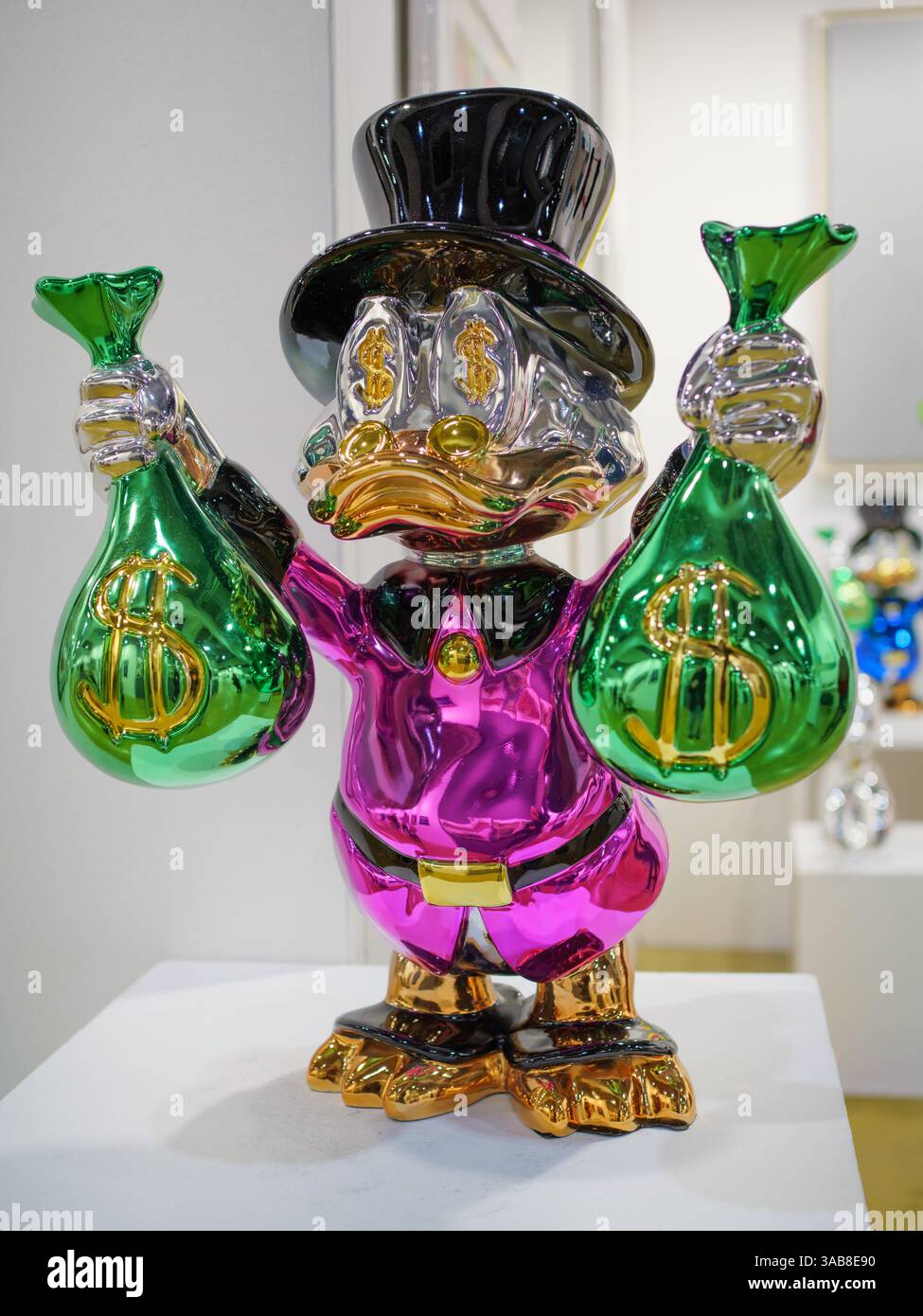 Reichtum Zeigen – Die Skulpturierte Ente Hält Glänzende Green Money Bags. Stockfoto