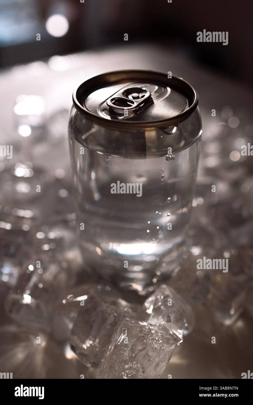 Nahaufnahme einer Dosendose mit Deckel mit Stahlring. Blick von oben. Das gekühlte Getränk liegt auf Eisstücken. Modell des Glases. Kopierbereich Stockfoto