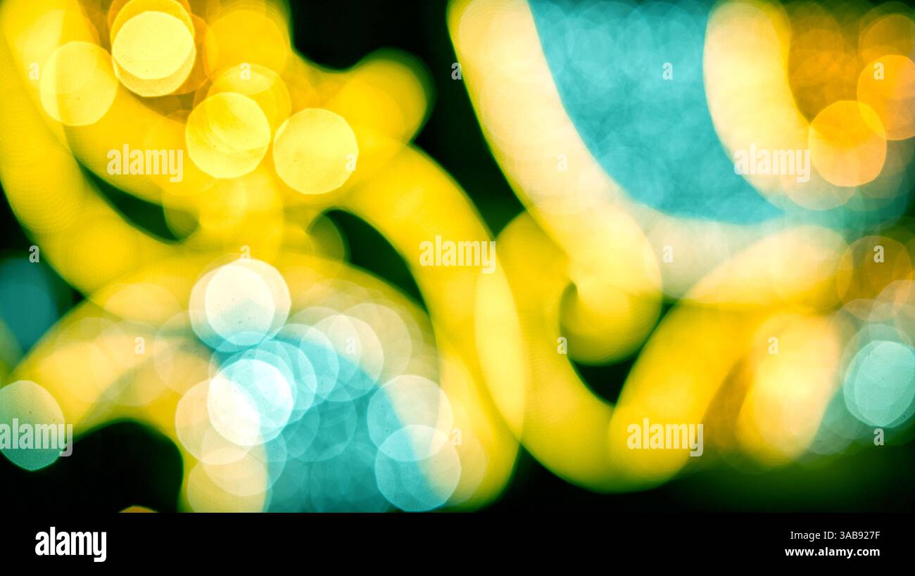 Sanft bewegliches Licht zeigt sich in einer verschwommenen Palette von hellen Farben mit kreisförmigen Formen, die eine energetische und abstrakte Atmosphäre hervorrufen. Stockfoto