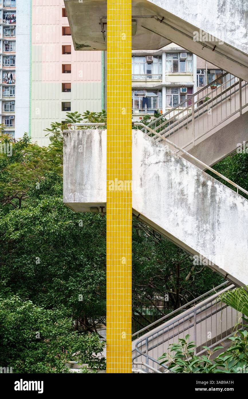 Eine Nahaufnahme, die die architektonischen Details und Strukturen einer öffentlichen Treppe vor Wohngebäuden in Hongkong hervorhebt. Die Kontraste Stockfoto