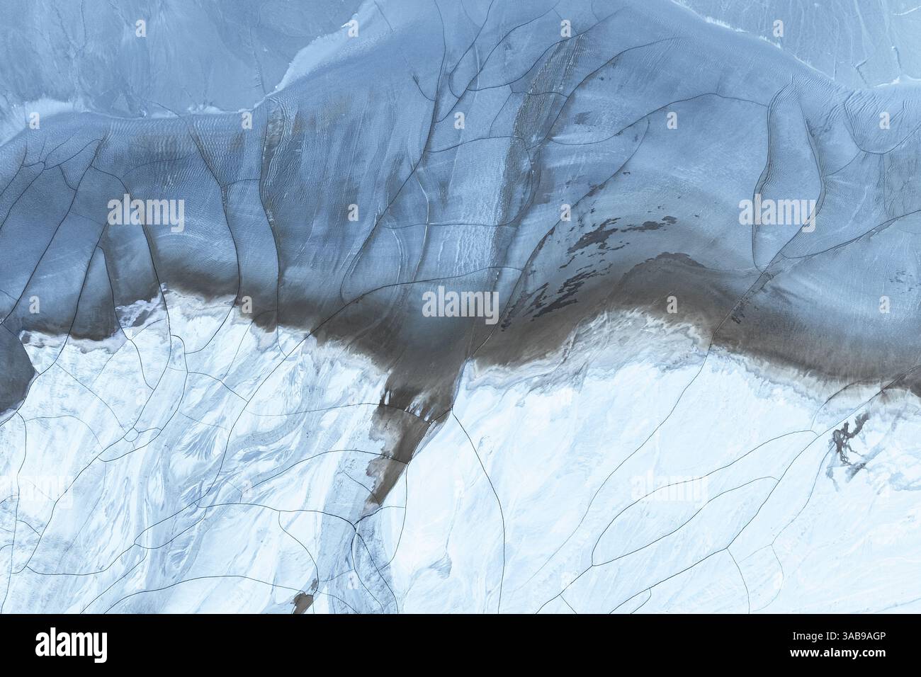 Ein atemberaubender Blick aus der Vogelperspektive zeigt abstrakte Muster aus Schlamm und Schnee in der arktischen Region, die die einzigartigen und komplizierten Designs der Natur in hervorheben Stockfoto