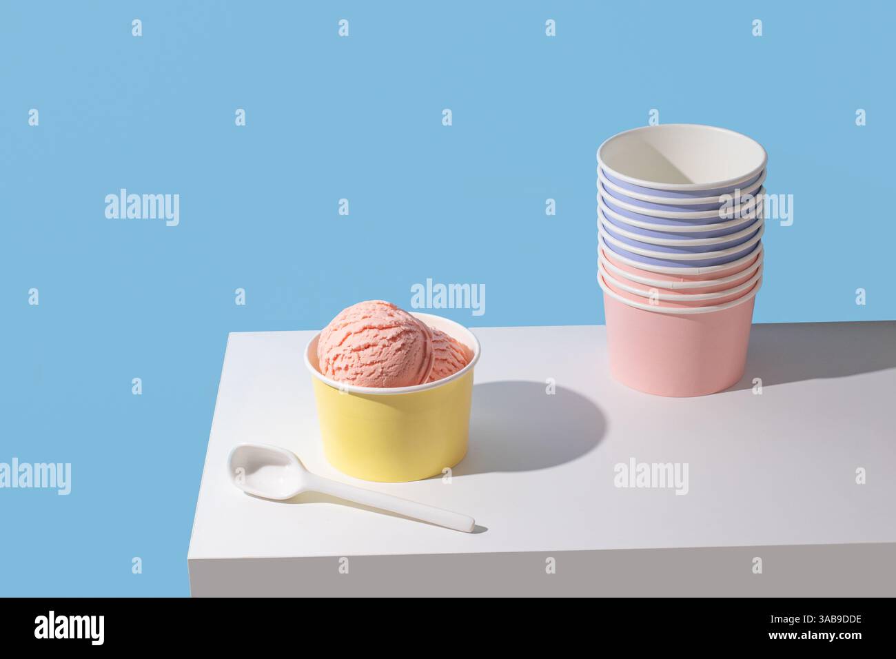 Eine minimalistische Präsentation von Erdbeereis. Die hellen Farben und der klare Hintergrund sorgen für ein modernes, auffälliges Bild. Stockfoto