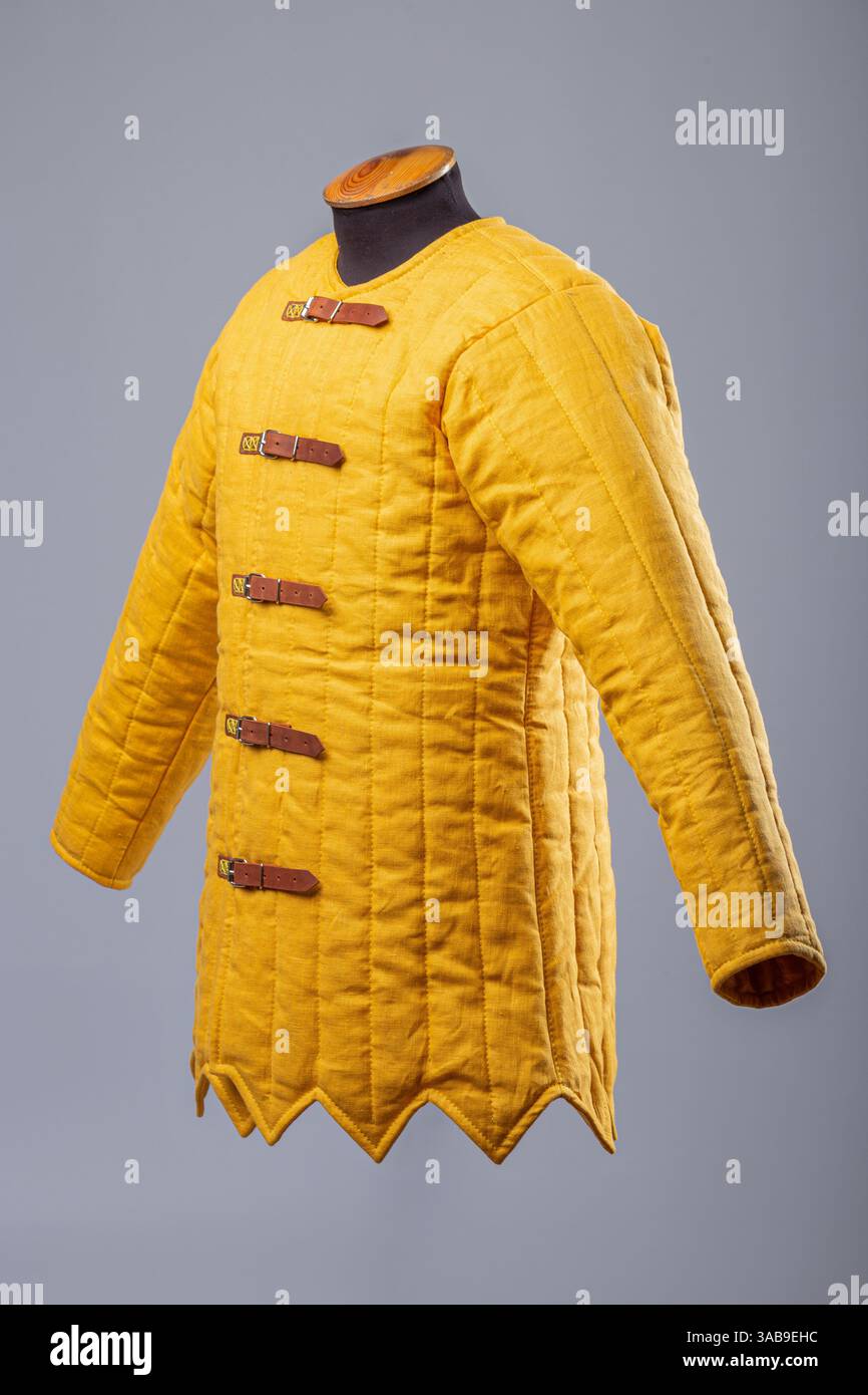 Gelbe Gepolsterte Gambeson-Jacke. Gesteppte Unterpanzerung im Mittelalter mit Lederriemen. Stockfoto