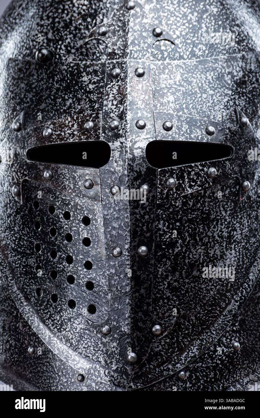 Geschlossener mittelalterlicher Ritterhelm mit kleinen Perforationen. Dieses Bild zeigt einen geschlossenen mittelalterlichen Ritterhelm, wahrscheinlich aus Stahl, mit einer spitzen Spitze Stockfoto