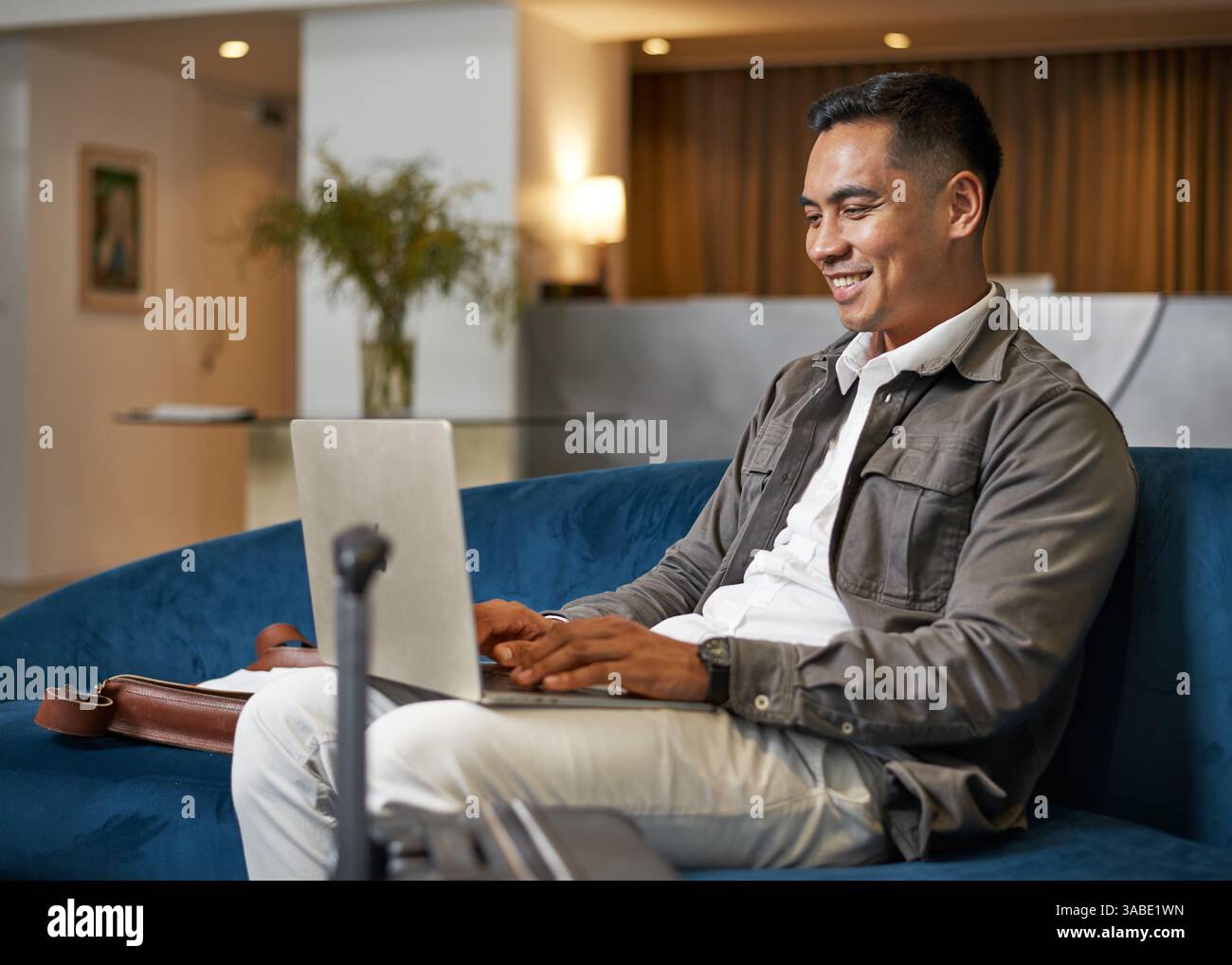 Business Professional mit Laptop in der modernen Lobby-Lounge des Hotels Stockfoto