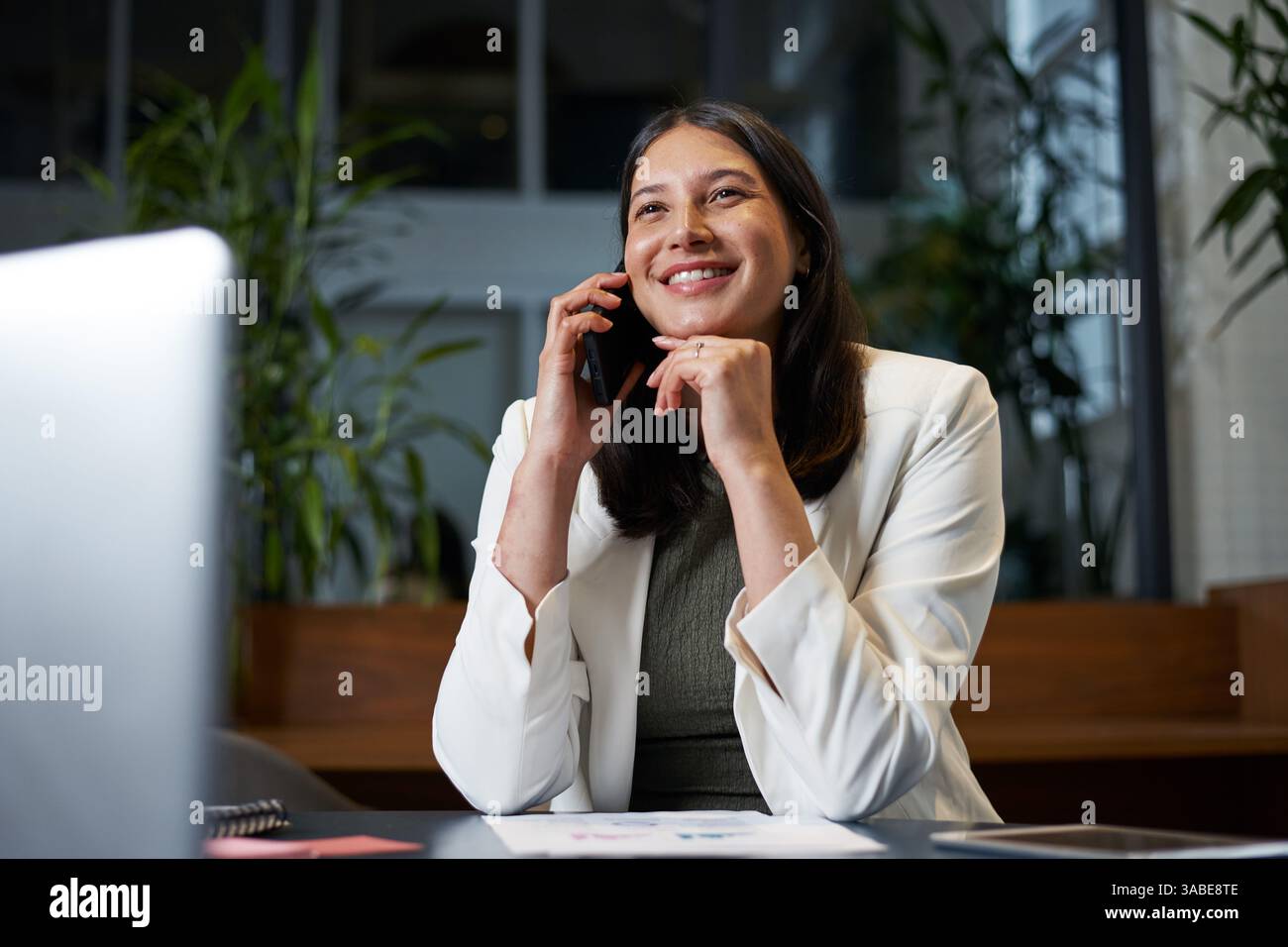 Selbstbewusste Geschäftsfrau telefoniert während der Arbeit in einer modernen Büroumgebung Stockfoto