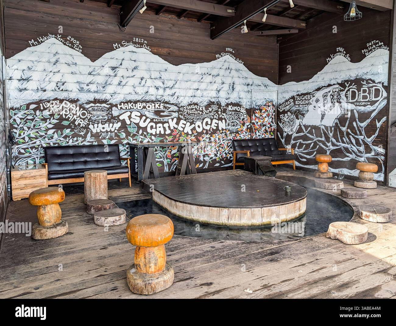 Komfortables Sofa neben dampfendem Fußbad im Skigebiet Tsugaike, Hakuba, Japan Stockfoto