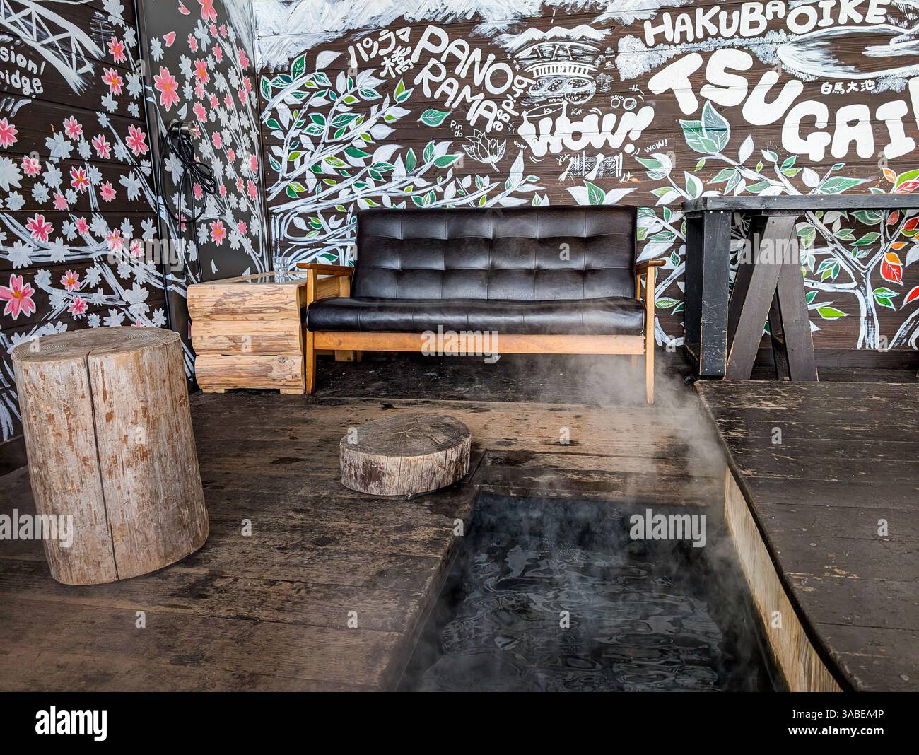 Komfortables Sofa neben dampfendem Fußbad im Skigebiet Tsugaike, Hakuba, Japan Stockfoto