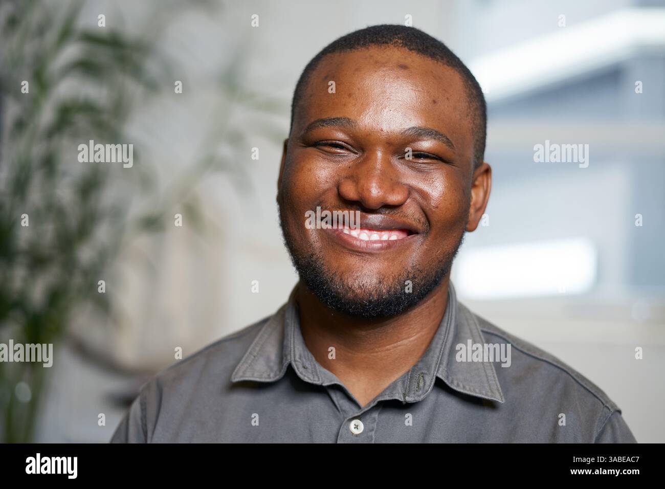 Porträt eines lächelnden Individuums in einer ungezwungenen Umgebung mit natürlichem Hintergrund Stockfoto