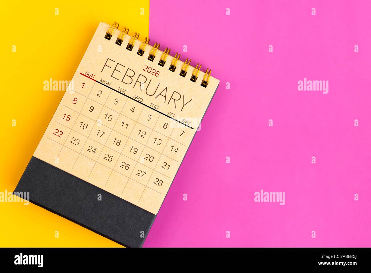 Februar 2026 Schreibtischkalender aus braunem Papier auf mehrfarbigem Papierhintergrund. Stockfoto