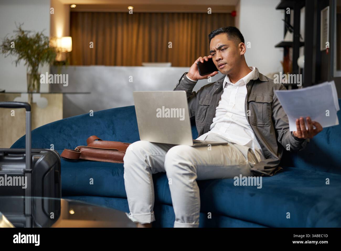 Geschäftsleute arbeiten während der Reise in der Hotellobby Stockfoto