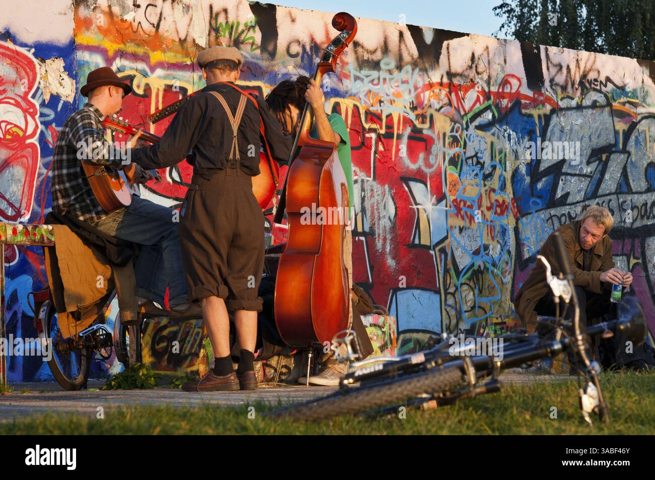 22. September 2010 - Berlin, Berlin, Deutschland - Musiker. Straßenfahrer an der Mauer im Mauerpark Berlin im Abendlicht Deutschland. Der Mauerpark ist ein öffentlicher Linearpark im Berliner Stadtteil Prenzlauer Berg. Der Name bedeutet „Mauerpark“ und bezieht sich auf seinen Status als ehemaliger Teil der Berliner Mauer und des Todesstreifens. Der Park liegt an der Grenze zwischen Prenzlauer Berg und Gesundbrunnen im ehemaligen West-Berlin. Im 19. Und 20. Jahrhundert diente der Mauerpark als Standort des Alten Nordbahnhofs, dem südlichen Endpunkt der Preußischen Nordbahn Stockfoto