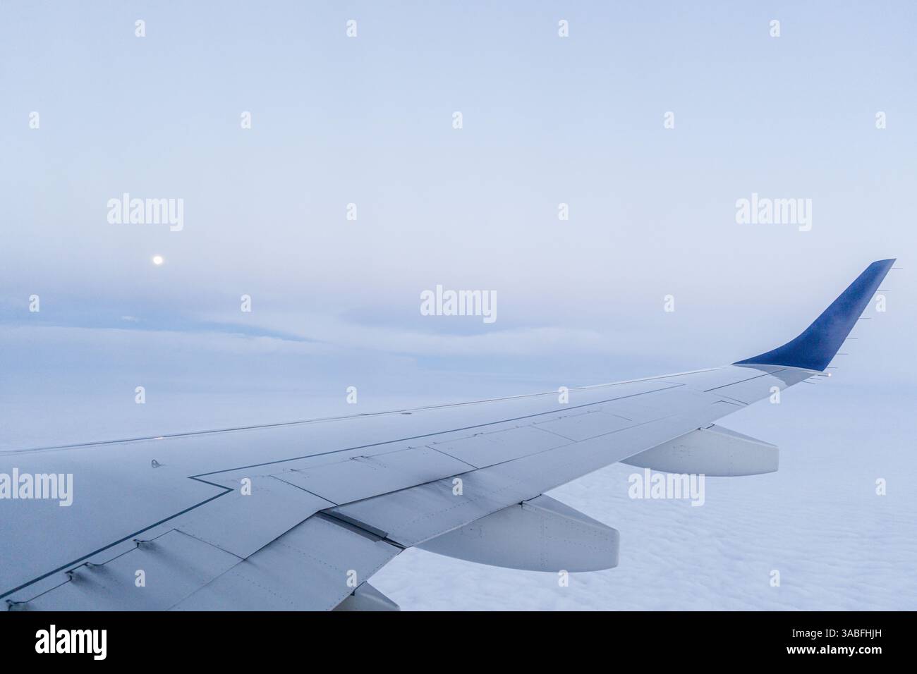 Nahaufnahme eines Flugzeugflügels im Flug an einem bewölkten Tag Stockfoto