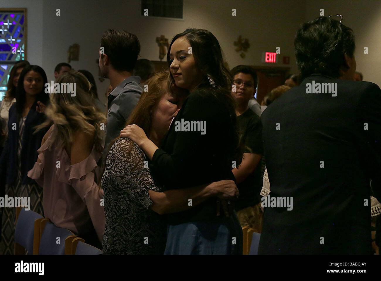 18. Mai 2018 – Miami, FL, USA – Dina Duran umarmt ihre Mutter Gina, während ihr Vater Orlando Duran (ganz rechts) Freunde und Familienmitglieder begrüßt, die sich ihnen bei einer Messe zur Feier des Geburtstags der FIU-Schülerin Alexa M. Duran anschloss, die am 15. März unter der gestürzten FIU-Sweetwater UniversityCity-Brücke getötet wurde. Die Messe wurde am 18. Mai 2018 in der St Mark Catholic Church in Southwest Ranches gefeiert. (Kreditbild: © Pedro Portal/TNS via ZUMA Wire) Stockfoto