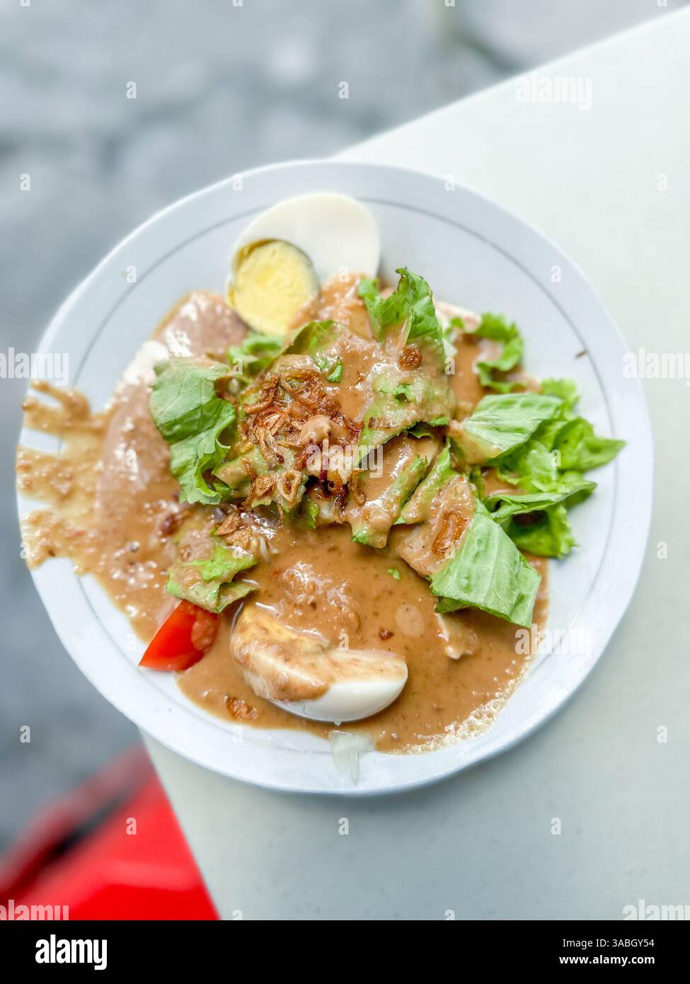 Gado Gado indonesischer Salat aus gekochtem Gemüse oder Dampfgemüse serviert mit Erdnusssauce - Smartphone-aufgenommenes Stockfoto