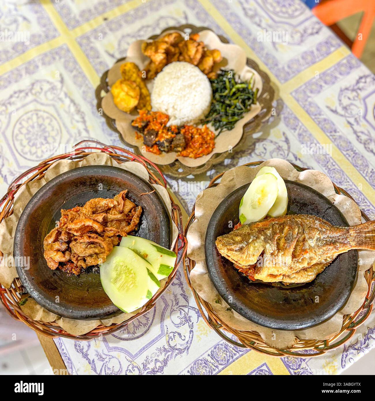 Indonesisches Essen von Nasi Lalapan mit gebratenem Fisch, knuspriger Hühnerhaut und Sambal Stockfoto