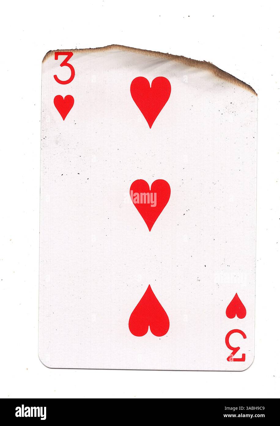 Eine teilweise verbrannte Spielkarte im Anzug der Herzen auf weißem Hintergrund. Stockfoto