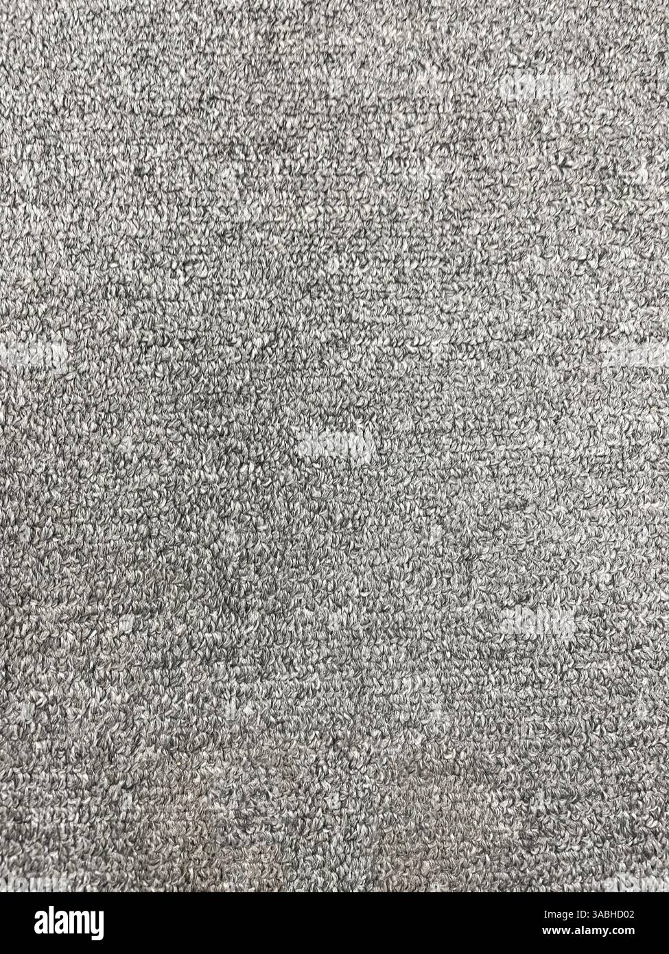 Nahtlose Nahaufnahme des einfarbigen grauen Teppichhintergrunds von oben. - Smartphone-aufgenommenes Stockfoto