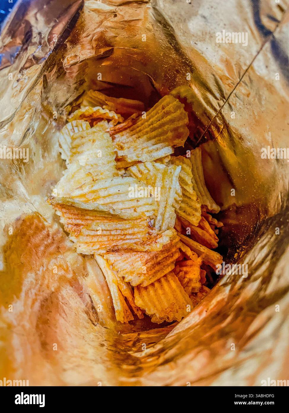 Draufsicht Nahaufnahme Foto auf einem Haufen frittierter Kartoffelchips in einer Plastiktüte, Junk und ungesundes Essen - Smartphone-aufgenommenes Stockfoto