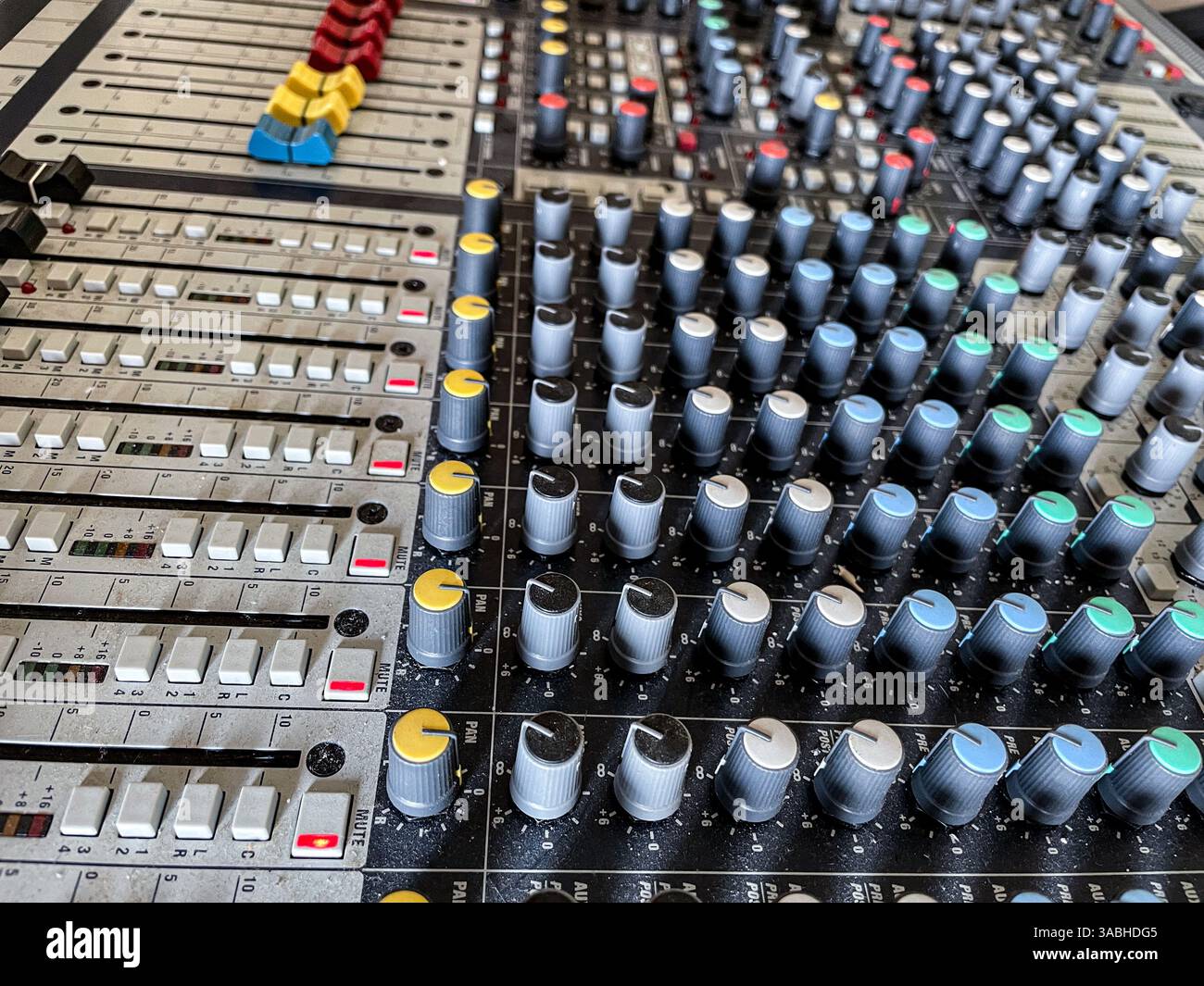 Steuerung des Mischers. Musiktechniker. Backstage-Bedienelemente an einem Audiomischer, Soundmischer. Professionelle Audio-Mischkonsole mit Leuchten, Tasten, Fadern und en - Smartphone-aufgenommenes Stockfoto