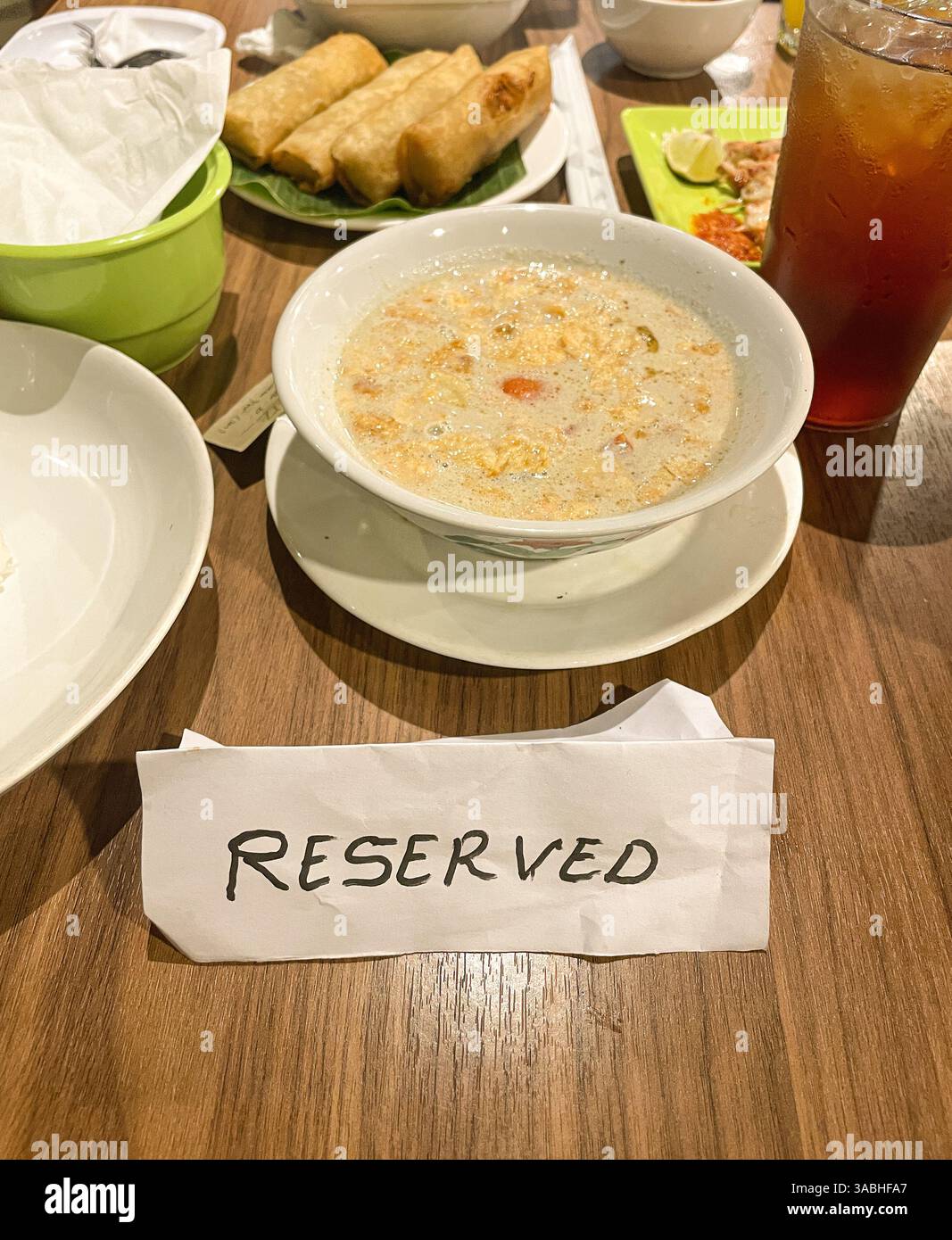 Reserviertes Schild auf dem Tisch im Restaurant mit Speisen serviert - Smartphone-aufgenommenes Stockfoto