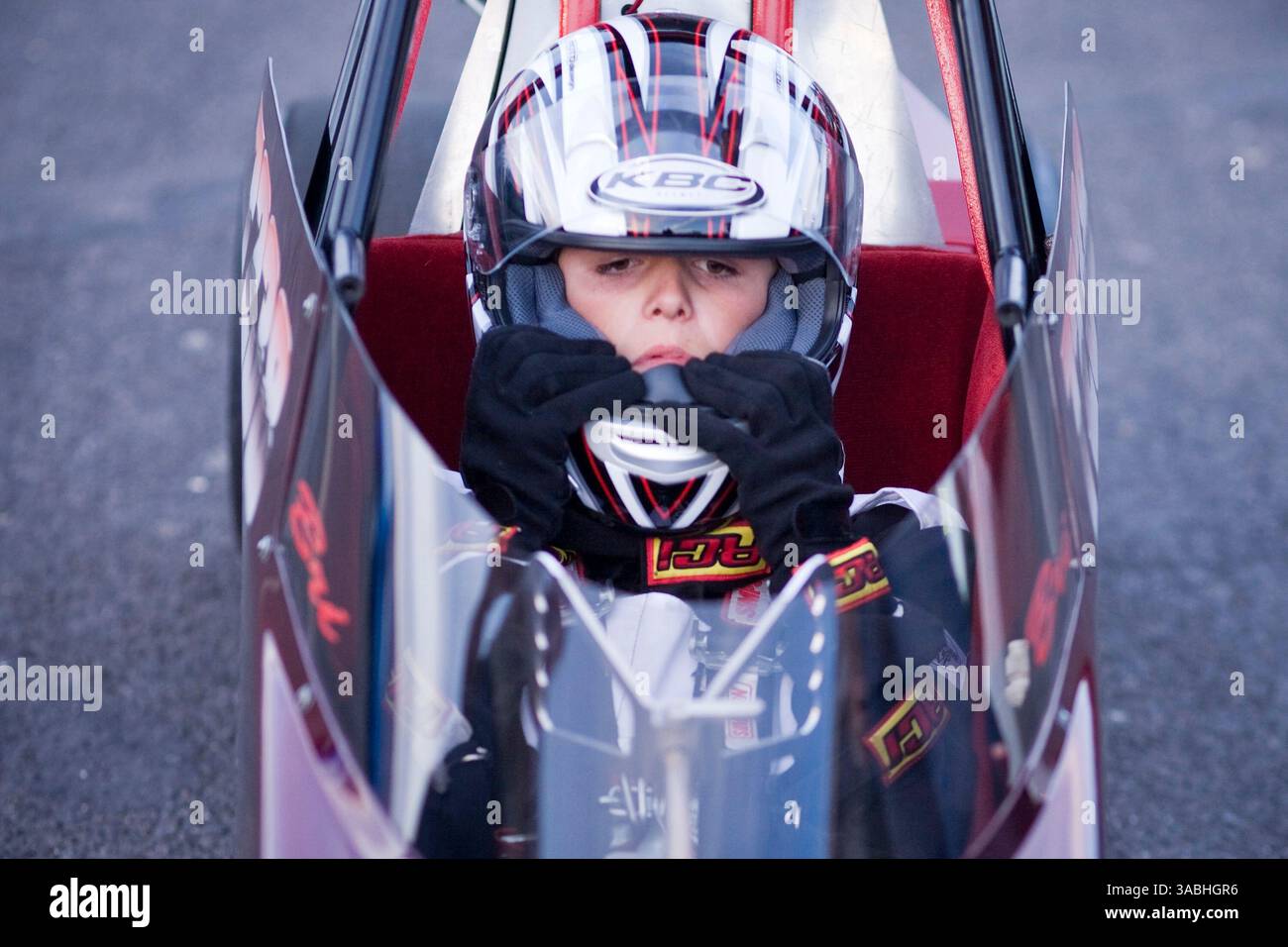 Juni 2007 – Phoenix, AZ, USA – DUSTIN PASSANT (12) aus Queen Creek, AZ, setzt seinen Helm im Cockpit des Junior Dragster auf, den er am Freitag Abend auf dem Firebird International Raceway in Phoenix, AZ fuhr. Es war das erste Mal, dass ein Passant das Auto fuhr. Junior Dragster sind halb so groß wie normale Dragster und werden von Kindern zwischen 8 und 18 Jahren angetrieben. Die Strecke fördert Freitagabend-Drags als Alternative zum Straßenrennen. Rennsportbegeisterte bringen ihre Autos, von denen die meisten Straßenzulassungen sind, auf die Rennstrecke und fahren gegeneinander. In den Wintermonaten bis zu 200 dri Stockfoto