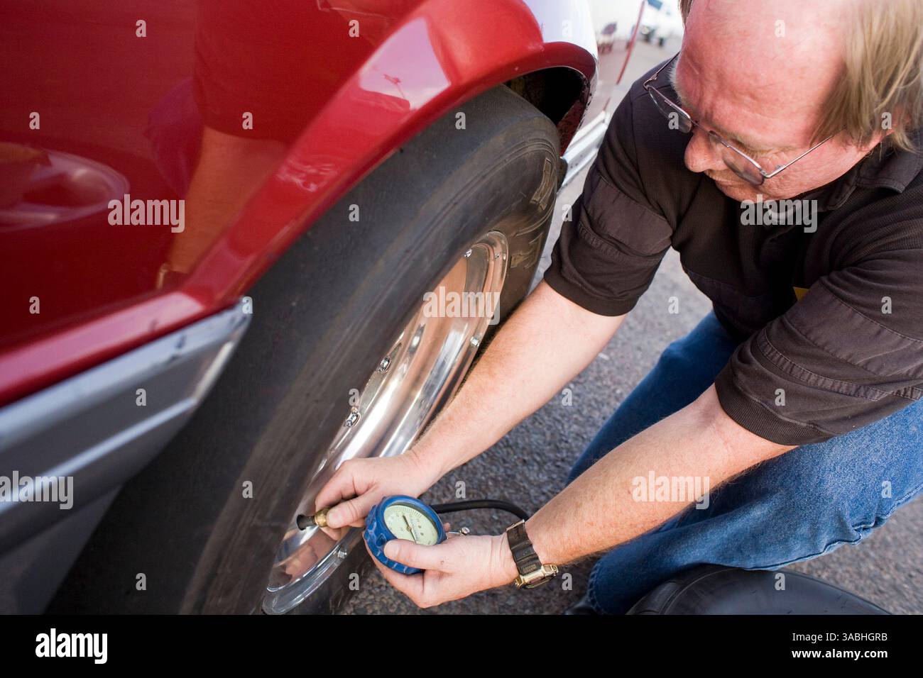 Juni 2007 - Phoenix, AZ, USA - GARY aus Chandler, AZ, kontrolliert seinen Reifendruck, bevor er während der Freitagnacht auf dem Firebird International Raceway in Phoenix, AZ, antritt. 1991 fuhr er in einem Ford Mustang GT. Die Strecke fördert Freitagabend-Drags als Alternative zum Straßenrennen. Rennsportbegeisterte bringen ihre Autos, von denen die meisten Straßenzulassungen sind, auf die Rennstrecke und fahren gegeneinander. In den Wintermonaten kommen bis zu 200 Fahrer auf die Strecke, im Sommer gibt es meist etwa 50 Autos auf der Strecke. Sie laufen die 1/4 Mile auf derselben Strecke wie National Hot Rod Asso Stockfoto