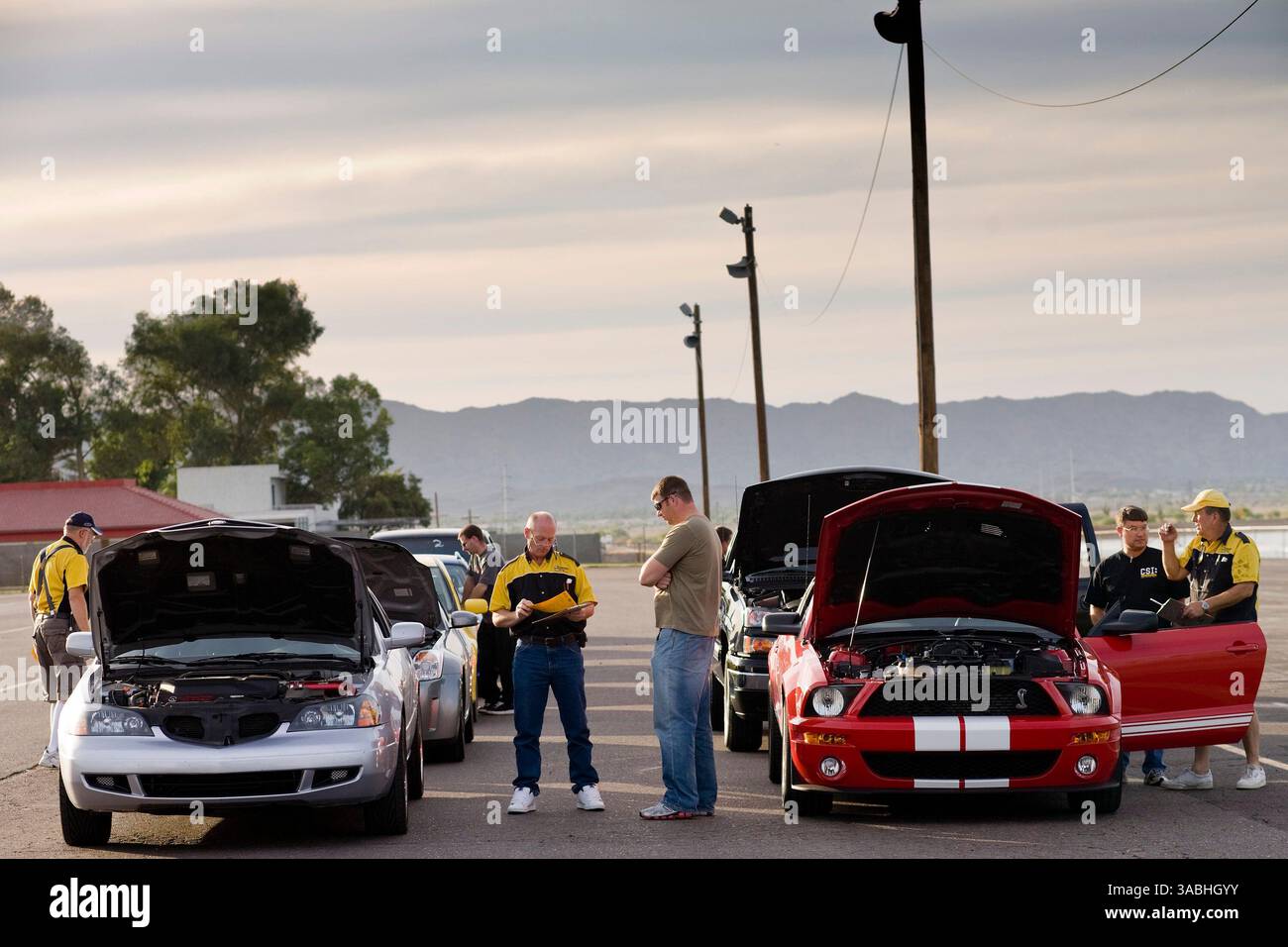 Juni 2007 – Phoenix, AZ, USA – Fahrer stehen an, um ihre Autos während der Drags am Freitag auf dem Firebird International Raceway in Phoenix, AZ, überprüfen zu lassen. Autos müssen eine Sicherheitsinspektion bestehen, und Fahrer müssen Sicherheitskleidung tragen, einschließlich Helme. Die Strecke fördert Freitagabend-Drags als Alternative zum Straßenrennen. Rennsportbegeisterte bringen ihre Autos, von denen die meisten Straßenzulassungen sind, auf die Rennstrecke und fahren gegeneinander. In den Wintermonaten kommen bis zu 200 Fahrer auf die Strecke, im Sommer gibt es meist etwa 50 Autos auf der Strecke. Sie laufen die 1/4 Meilen auf t Stockfoto
