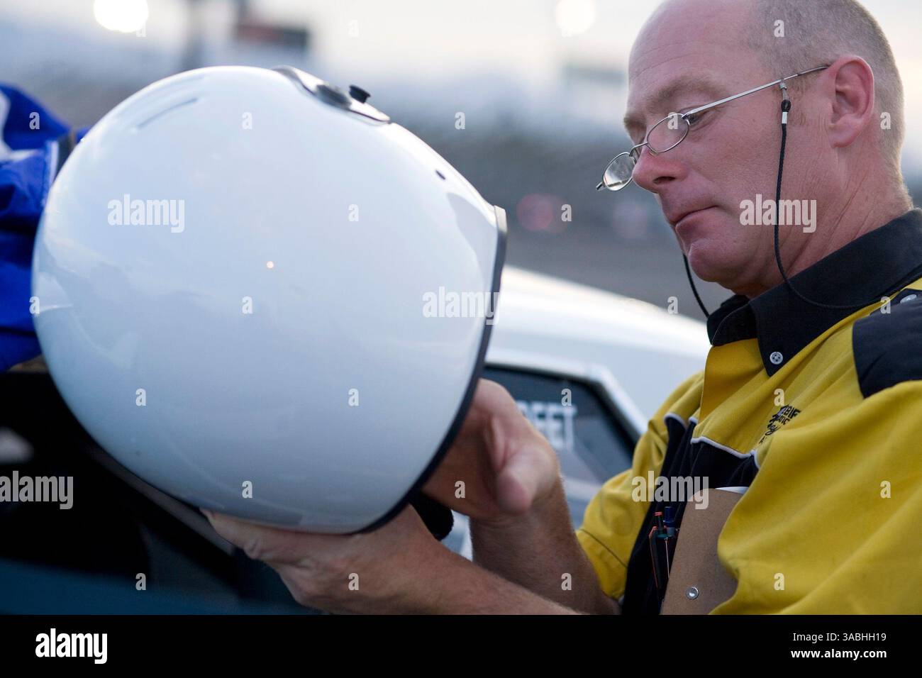Juni 2007 - Phoenix, AZ, USA - Ein technischer Inspektor überprüft während der Freitagnacht auf dem Firebird International Raceway in Phoenix, AZ, einen Fahrerhelm. Die Strecke fördert Freitagabend-Drags als Alternative zum Straßenrennen. Rennsportbegeisterte bringen ihre Autos, von denen die meisten Straßenzulassungen sind, auf die Rennstrecke und fahren gegeneinander. In den Wintermonaten kommen bis zu 200 Fahrer auf die Strecke, im Sommer gibt es meist etwa 50 Autos auf der Strecke. Sie laufen die 1/4 Meilen auf der gleichen Strecke, die die Profis der National Hot Rod Association (NHRA) bei ihren Winterrennen in Phoenix benutzen. (Guthaben Stockfoto
