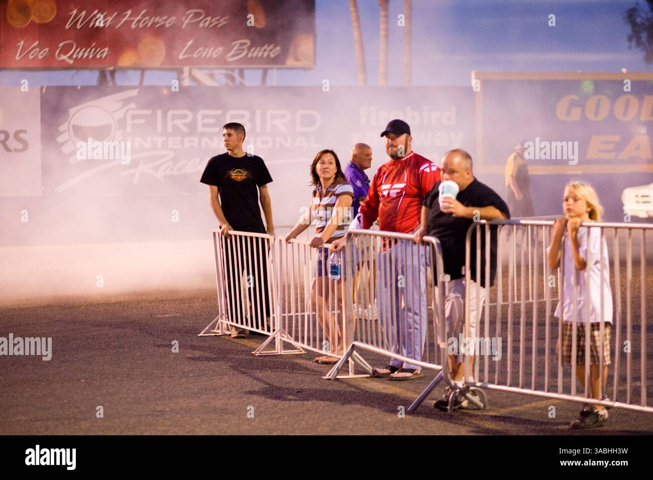 Juni 2007 - Phoenix, AZ, USA - Zuschauer stehen während der Freitagnacht auf dem Firebird International Raceway in Phoenix, AZ, im Auspuff von Rennwagen. Die Strecke fördert Freitagabend-Drags als Alternative zum Straßenrennen. Rennsportbegeisterte bringen ihre Autos, von denen die meisten Straßenzulassungen sind, auf die Rennstrecke und fahren gegeneinander. In den Wintermonaten kommen bis zu 200 Fahrer auf die Strecke, im Sommer gibt es meist etwa 50 Autos auf der Strecke. Sie laufen die 1/4 Meilen auf der gleichen Strecke, die die Profis der National Hot Rod Association (NHRA) bei ihren Winterrennen in Phoenix benutzen. (Guthaben Im Stockfoto