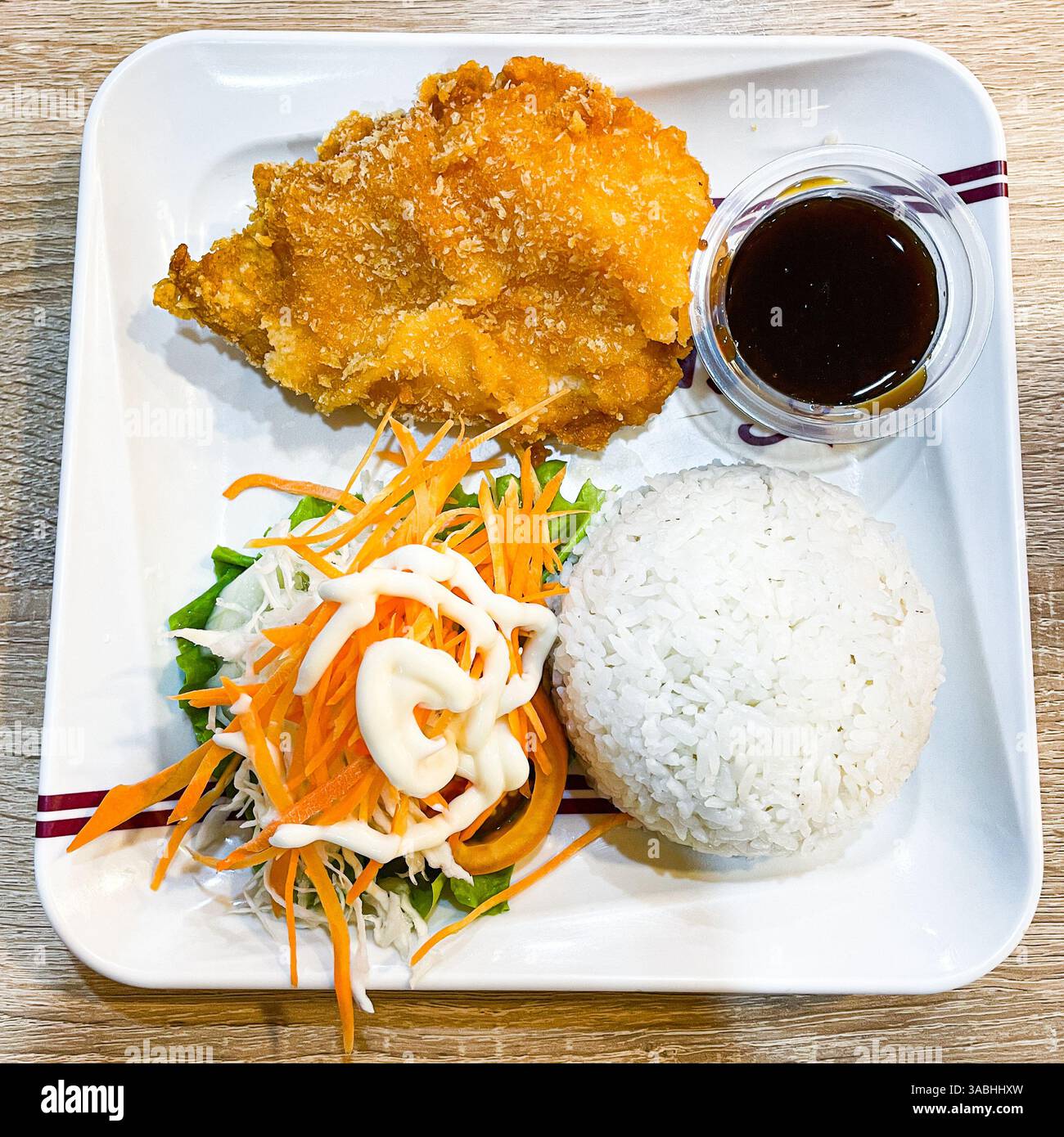 Katsu Huhn und Reis und es gibt Salate, Karotten und Mayonnaise. Es ist scharf, knusprig und köstlich - Smartphone-aufgenommenes Stockfoto