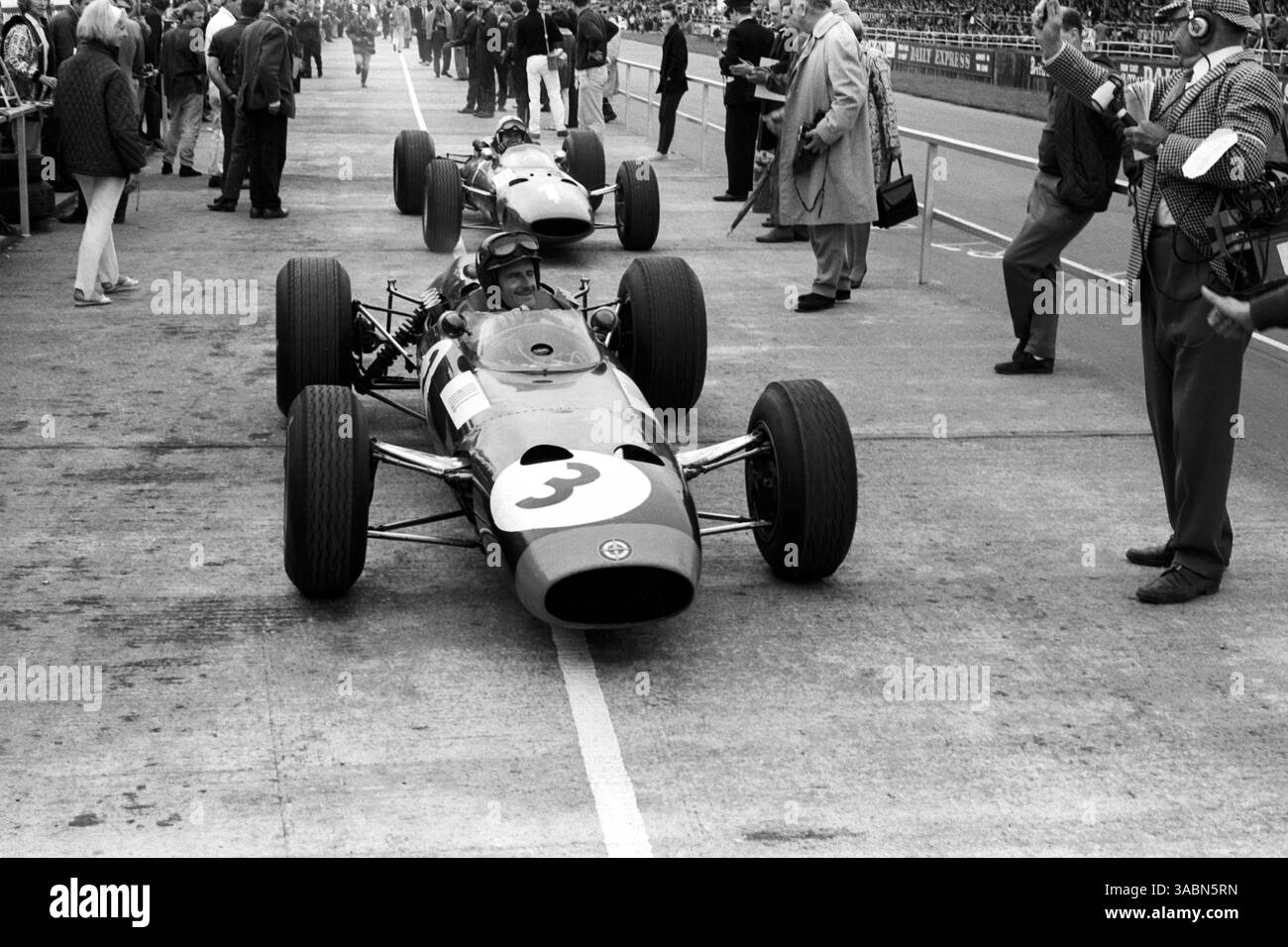 Der zweite Platz, Graham Hill (GBR) BRM P261, kommt im Parc Ferme an, der dritte Platz John Surtees (GBR) Ferrari 1512, der knapp hinter sich liegt...britischer Grand Prix, Silverstone, 10. Juli 1965. (Kreditbild: ©Sutton Motorsports/ZUMA Press) Stockfoto