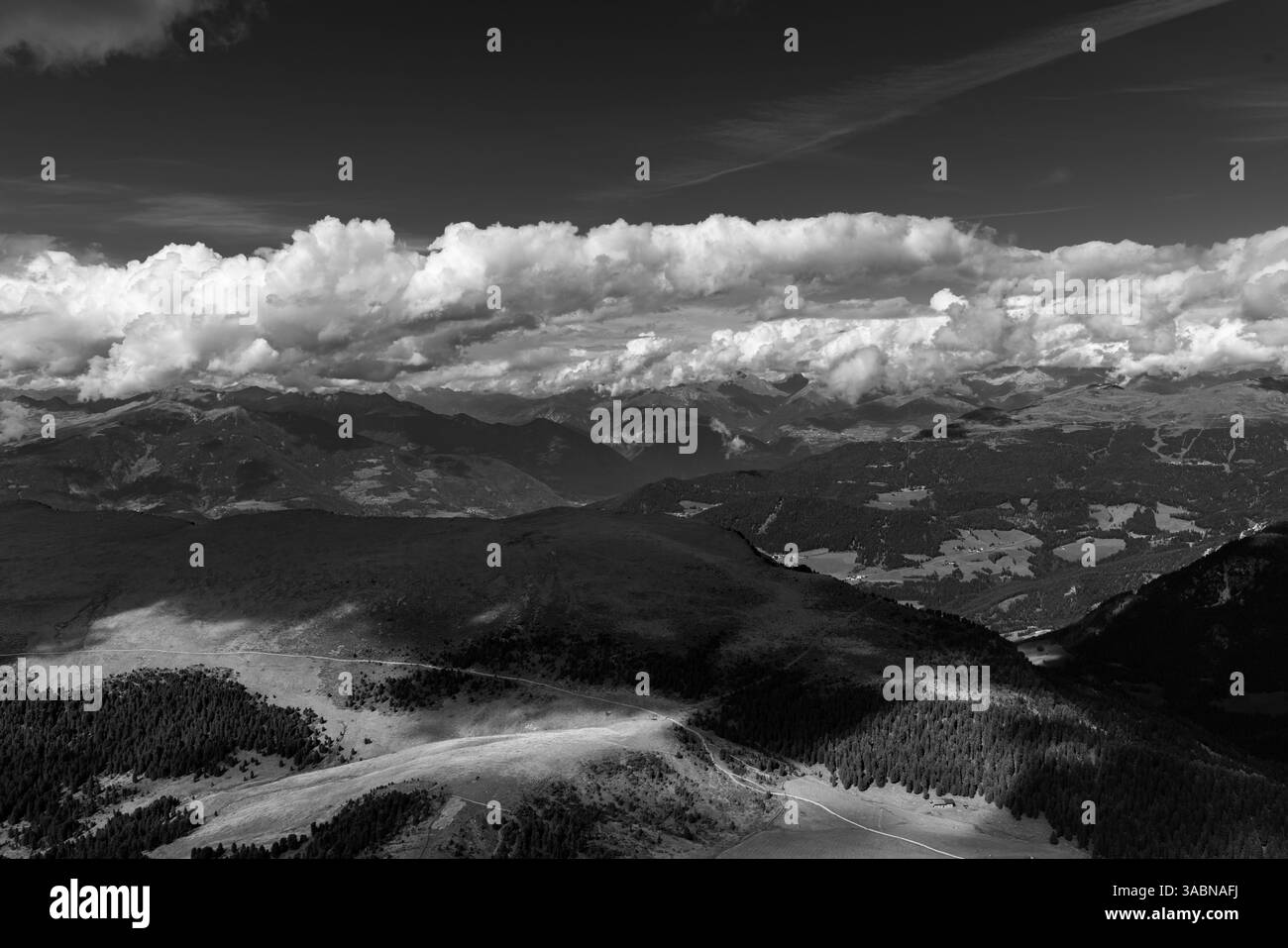 Blick von den Wolken der Dolomiten Berge, die schwarz-weiß von der Sonne beleuchtet werden Stockfoto