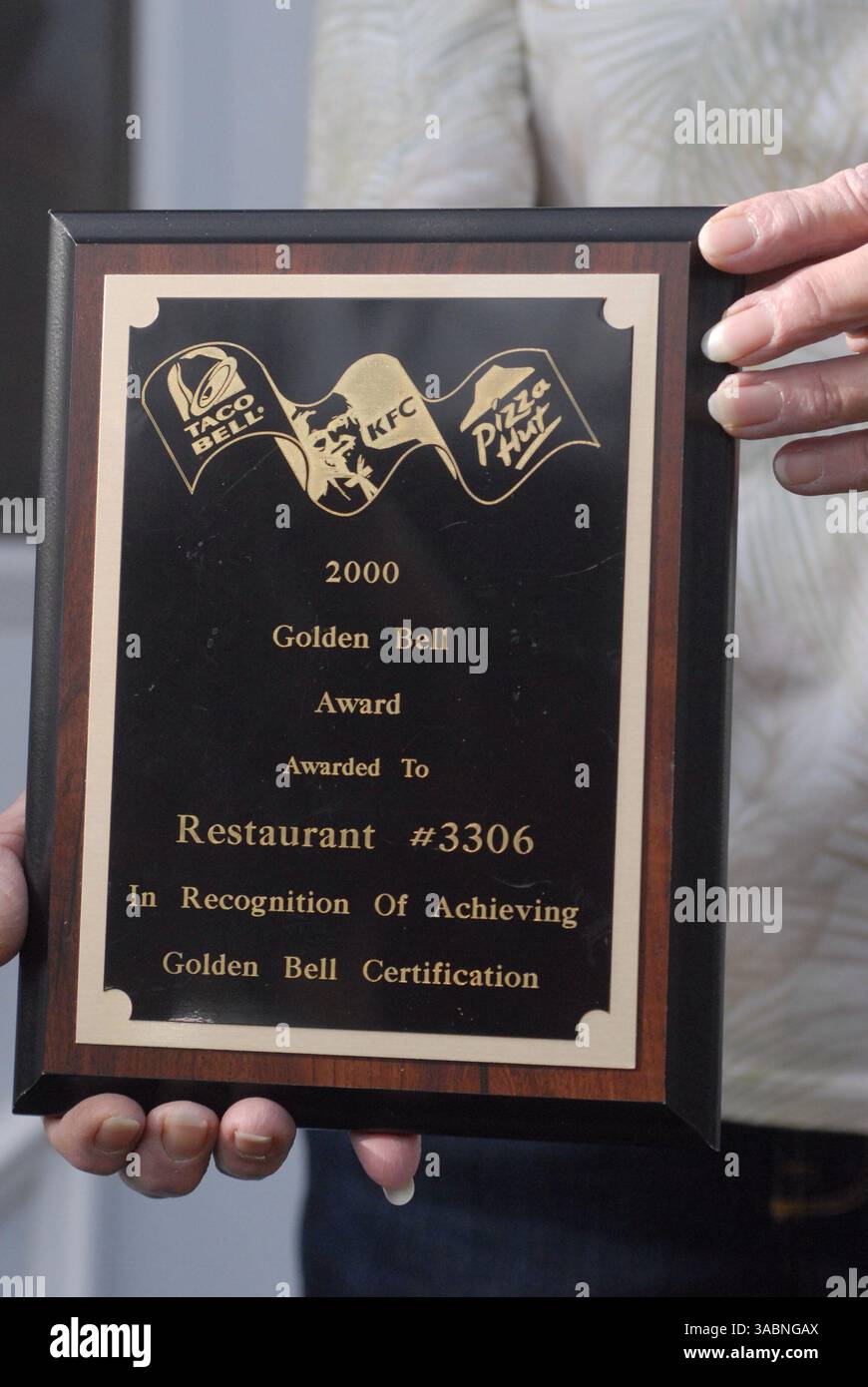 November 2007; Edina, MN, USA; WINNIE SHILSON hat seit 30 Jahren nie einen Arbeitstag verpasst und erhielt erstklassige Leistungsbewertungen und Auszeichnungen. Aber nachdem sie zwei Raubüberfälle überlebt hatte, bei denen sie verletzt wurde, ließ die Firma Winnie, 64, wie einen heißen Tamale fallen. Sie reiben heiße Soße in die Wunde und haben die Großmutter von sechs Jahren gehackt, ohne ihr einen Transfer, eine Degradierung, Abfindungsentgelt oder gesundheitliche Vorteile anzubieten. "Sie haben ihr nichts gegeben, nicht einmal einen Taco", murrt ihr Mann Doug, ein pensionierter Lkw-Fahrer. IM BILD: WINNIE SHILSON hält Taco Bell's Golden Bell Aacheivement Plaque – die höchste Auszeichnung Stockfoto