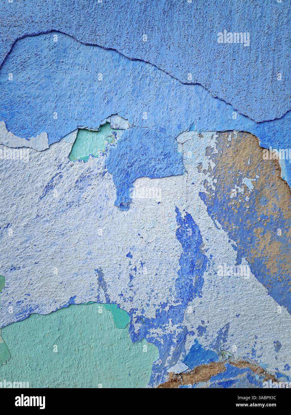 Gerissene, abblätternde Wand mit unterschiedlichen Schichtfarben. Abstrakte Textur der verwitterten Kalkfassade - Smartphone-aufgenommenes Stockfoto