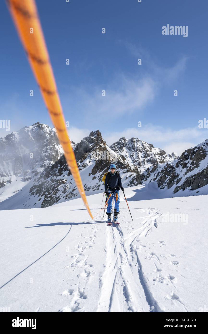 Skitourer mit Seil, Seilteam auf dem Gletscher Vadret da Porchabella beim Aufstieg zum Gipfel des Piz Kesch, Berglandschaft im Winter, alpines To Stockfoto