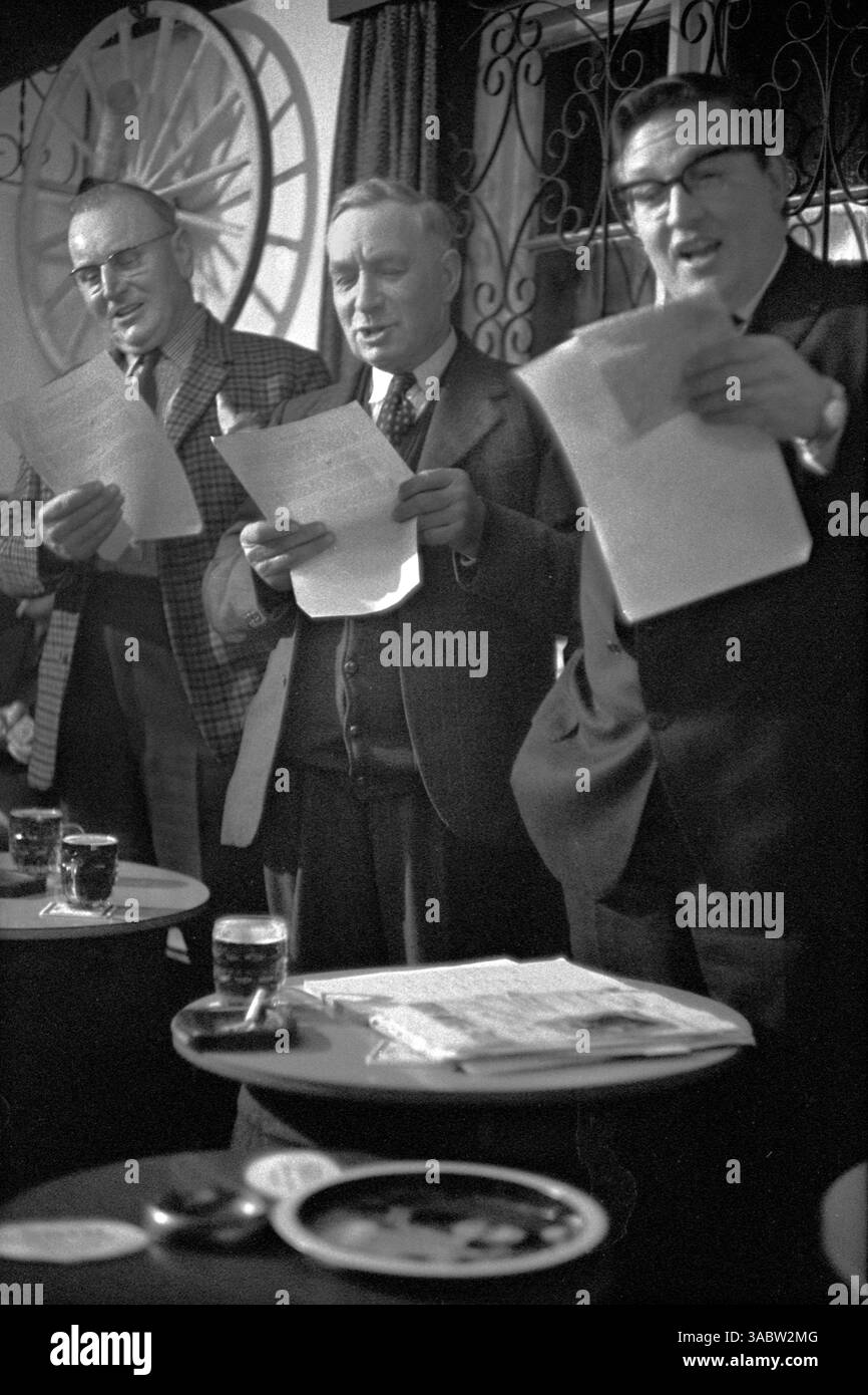 Männer singen traditionelle Volkslieder in einem Dorfkneipe. Eine Gruppe von Landwirten, die einen Abend verbringen. The Gate Inn, Ratcliffe Culey, Leicestershire England 1968 1960er Jahre Großbritannien HOMER SYKES Stockfoto