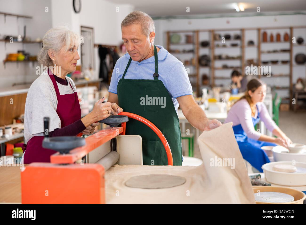 potter arbeitet mit der Tonpresswalze der Schülermaschine Stockfoto