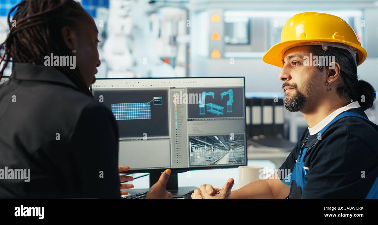 Arbeiter in der Photovoltaik-Fabrik diskutiert mit Frau über die Systemleistung. Produktionsanlage für Solarpaneele afroamerikanischer Manager im Gespräch mit Ingenieur über Energieerzeugung, Kamera B Stockfoto