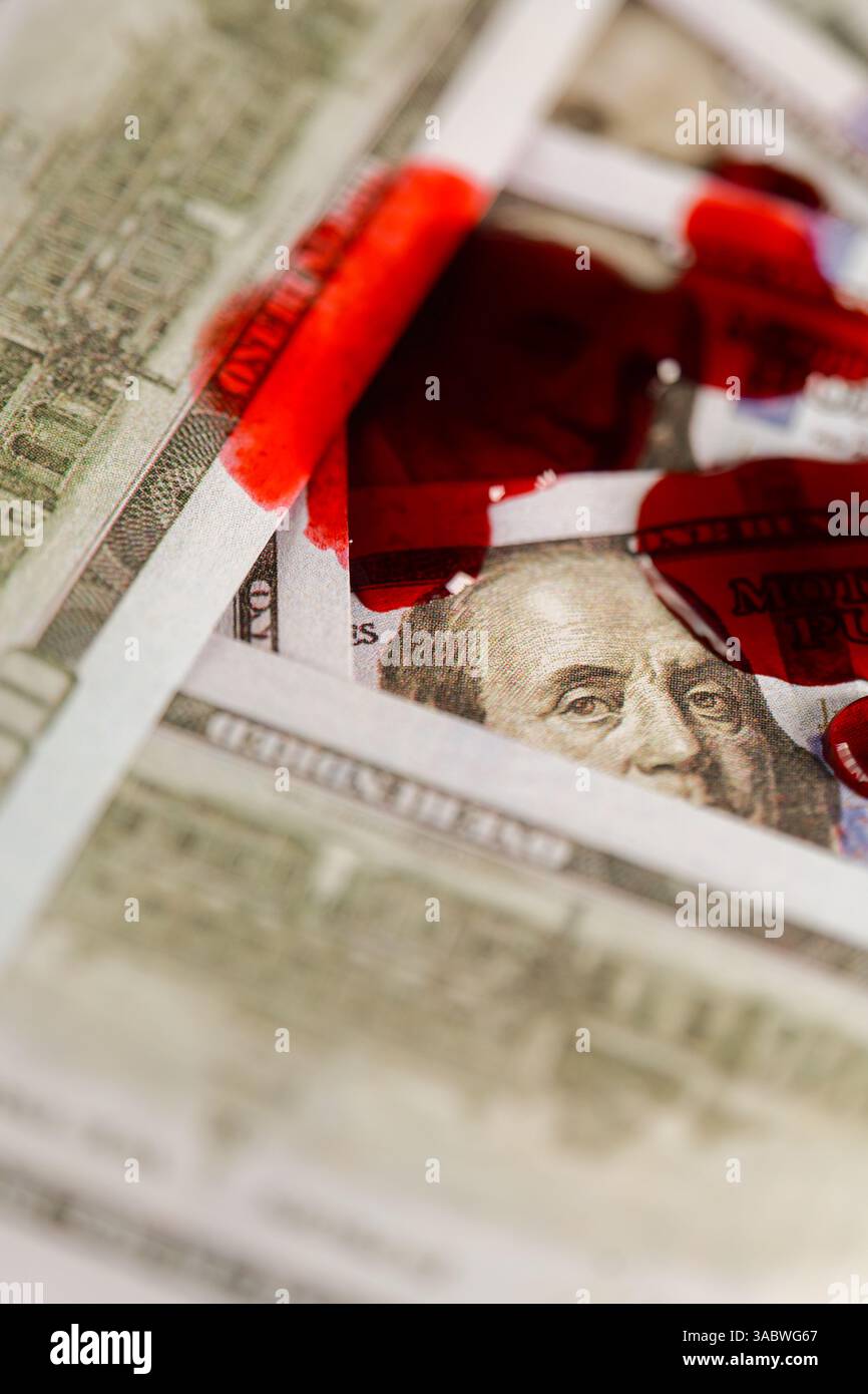 Blutflecken auf Dollar-Scheinen. Verdammt kriminelle Finanzen. Tropfen Blut fallen auf Dollar. Benjamin Franklins Gesicht auf der Rechnung ist in Blut. Das Blut fließt langsam Stockfoto