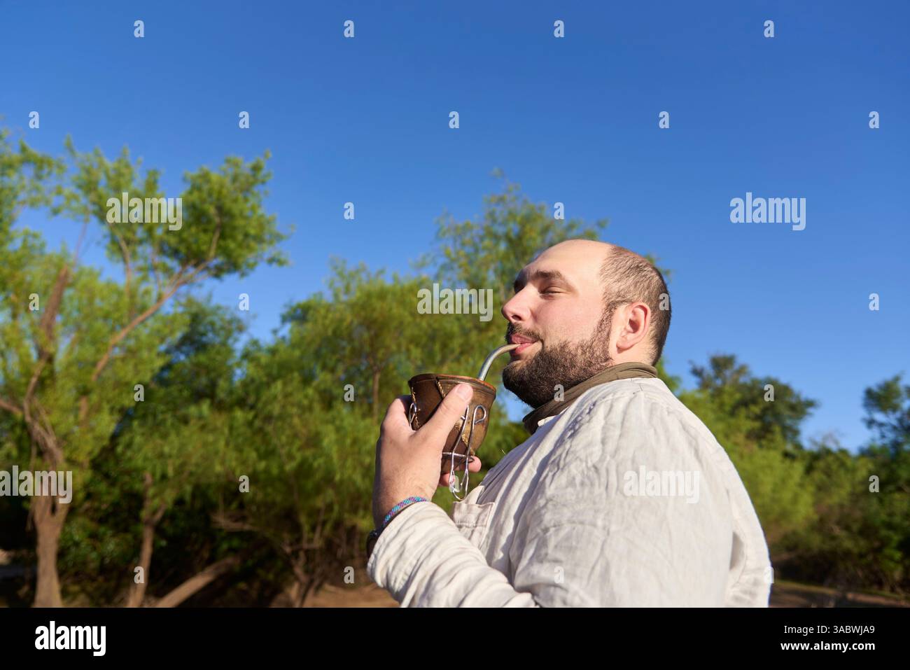 Der hispanische Mann verbringt viel Zeit im Freien und genießt einen Drink Mate, eine traditionelle argentinische Infusion. El Palmar Nationalpark, Entre Rios, Argentinien. Stockfoto
