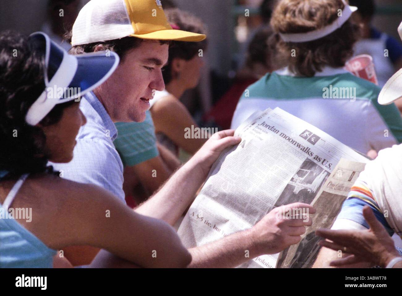 Los Angeles, Kalifornien, USA, 1984. Zuschauer im Stadion lesen während der Olympischen Sommerspiele die Sportseiten einer Zeitung. Stockfoto